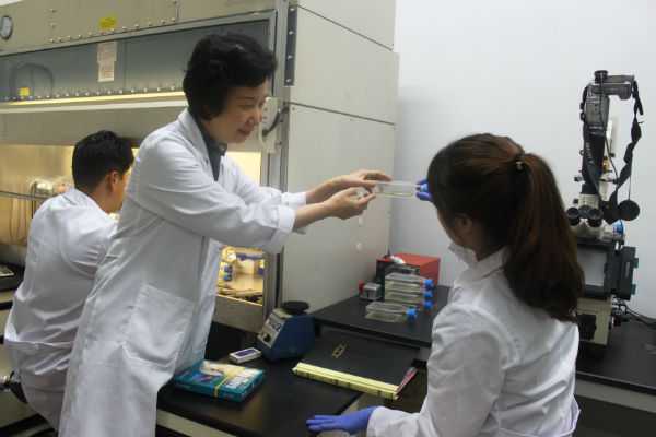 실험실에서 김민영 대표와 연구원이 의견을 나누고 있다.